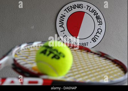 (ILLUSTRATION) une illustration photo montre le logo du club à un mur avec une raquette de tennis et une balle dans l'avant-plan sur le terrain de tennis sur gazon-, Turner-Clubs (LTTC) Rot-Weiß-Berlin, accueil de joueur de tennis professionnel Sabine Lisicki, à Berlin, Allemagne, 05 juillet 2013. Le 06 juillet Lisicki joue dans la finale de Wimbledon. Photo : PAUL ZINKEN Banque D'Images