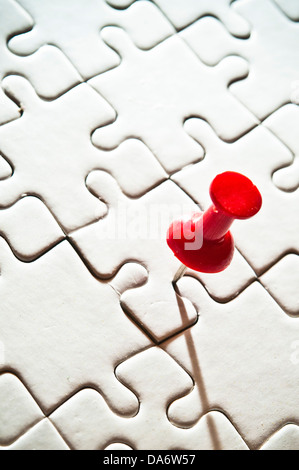 Broche rouge sur un fond noir puzzle Banque D'Images
