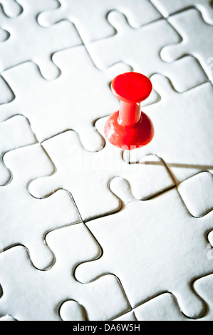 Broche rouge sur un fond noir puzzle Banque D'Images
