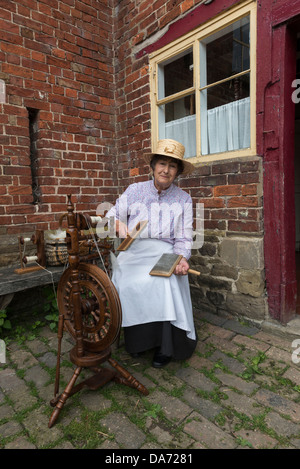 Acton Scott ferme. Femme en costume victorien part carder la laine. Le Shropshire. L'Angleterre. UK Banque D'Images