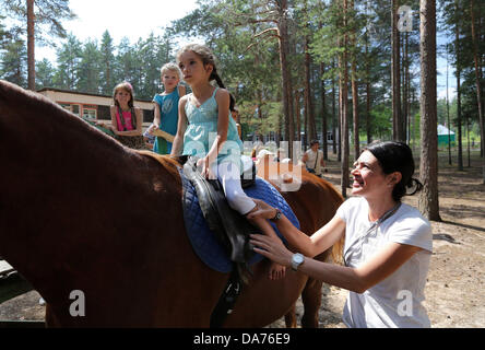 Juillet 05, 2013 - Saint-Pétersbourg, Russie - Les enfants de monter des chevaux à l'amélioration de la santé 'complexe lumière verte." Le complexe offre des soins de santé, la condition physique, des loisirs et de réhabilitation pour les enfants handicapés et les maladies rares. Les familles nombreuses et les familles monoparentales qui inscrivent leurs enfants à l'un reçu sur l'un des soins. (Crédit Image : © Andreï Pronin/ZUMAPRESS.com) Banque D'Images