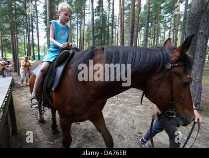 Juillet 05, 2013 - Saint-Pétersbourg, Russie - Les enfants de monter des chevaux à l'amélioration de la santé 'complexe lumière verte." Le complexe offre des soins de santé, la condition physique, des loisirs et de réhabilitation pour les enfants handicapés et les maladies rares. Les familles nombreuses et les familles monoparentales qui inscrivent leurs enfants à l'un reçu sur l'un des soins. (Crédit Image : © Andreï Pronin/ZUMAPRESS.com) Banque D'Images