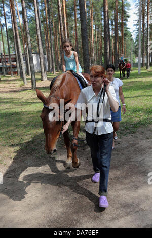 Juillet 05, 2013 - Saint-Pétersbourg, Russie - Les enfants de monter des chevaux à l'amélioration de la santé 'complexe lumière verte." Le complexe offre des soins de santé, la condition physique, des loisirs et de réhabilitation pour les enfants handicapés et les maladies rares. Les familles nombreuses et les familles monoparentales qui inscrivent leurs enfants à l'un reçu sur l'un des soins. (Crédit Image : © Andreï Pronin/ZUMAPRESS.com) Banque D'Images