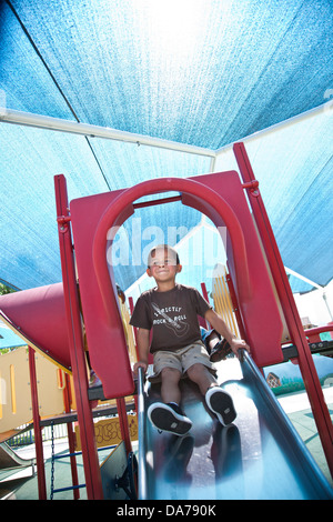 Enfants jouant sur une aire de glisse hispanic asain caucasian Banque D'Images