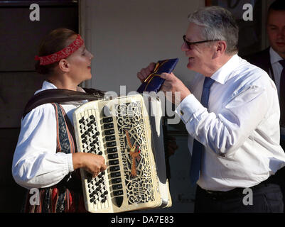 Savonlinna, Finlande. 05 juillet, 2013. Le Président allemand Joachim Gauck grâce un joueur d'accordéon pour terminer sa musique et lui donne un cadeau à Savonlinna, Finlande, 05 juillet 2013. Photo : WOLFGANG KUMM/dpa/Alamy Live News Banque D'Images