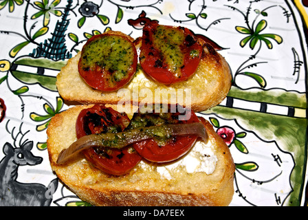 Tomates cerises grillées au pesto de basilic parmesan bruschetta au fromage de chèvre apéritif avec sans filet d'anchois Banque D'Images