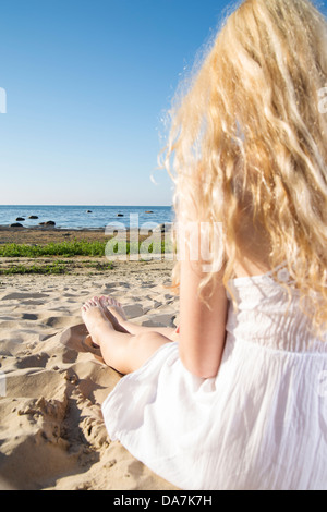Femme en robe blanche s'étend le long des jambes Banque D'Images