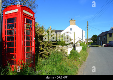 La boîte rouge traditionnel téléphone sur un village lane. Banque D'Images