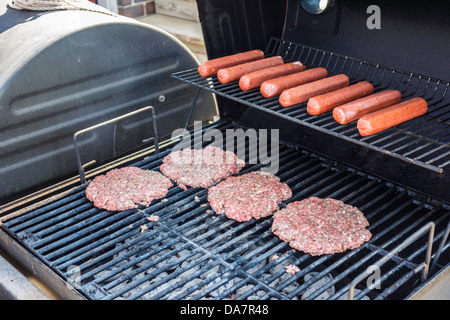 Hamburgers et hot-dogs cuits sur un barbecue en plein air. USA. Banque D'Images