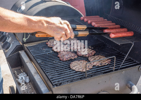 Hamburgers et hot-dogs cuits sur un barbecue en plein air. USA. Banque D'Images