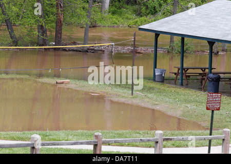 Une rivière inondé de récréation dans le parc avec filet de volley-ball et des bancs de pique-nique au printemps Banque D'Images