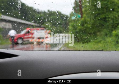 Un barrage routier en raison d'une route inondée comme vu par l'essuie des pluies d'une voiture Banque D'Images