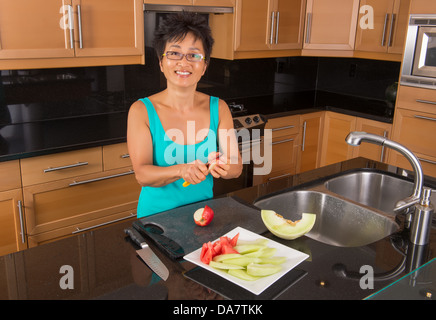 Femme Asiatique dans sa cuisine fruits côtelettes pour plateau à fruits Banque D'Images