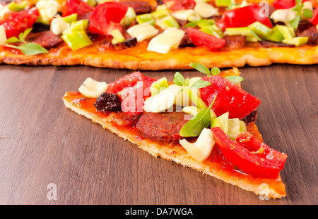 Des légumes frais et des saucisses sur la pizza sandwich. Selective focus au milieu de la tranche Banque D'Images