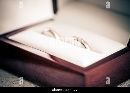 Les anneaux de mariage dans une boîte avec l'arrière-plan flou bouquet sur Banque D'Images