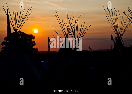 Tipis en silhouette contre le coucher du soleil à Glastonbury Festival, 2013 Banque D'Images