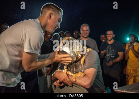 US Marine Corps Lance Cpl. Christian Laverdière hits est le commandant le Capitaine Raymond Kaster au visage avec une paire de tartes lors de commémorations de l'indépendance à bord du USS Carter Hall le 4 juillet 2013 dans la mer d'Oman. Banque D'Images