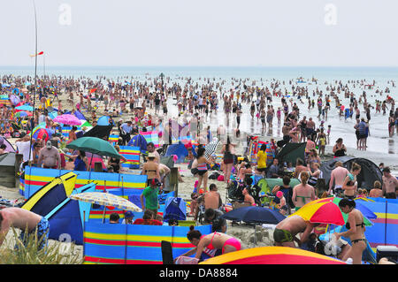 West Wittering, West Sussex, UK. 7 juillet, 2013. Sizzling le dimanche comme jour-trippers prendre à la populaire West Wittering beach pour se rafraîchir car les températures ont atteint 30 degrés à l'intérieur des terres, dans le sud de l'Angleterre 2e parking ouvert pour accueillir jusqu'à 10.000 voitures.Les iphone et ipad sont prêts à diffuser le tournoi de tennis de Wimbledon en tentes de plage et parasols Crédit : Gary Blake/Alamy Live News Banque D'Images