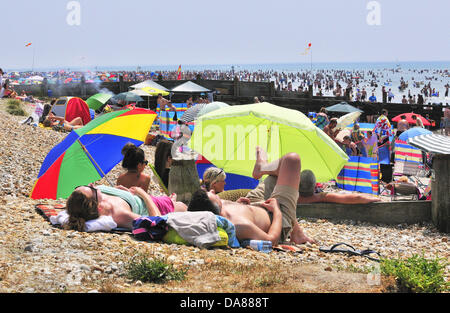 West Wittering, West Sussex, UK. 7 juillet, 2013. Sizzling le dimanche comme jour-trippers prendre à la populaire West Wittering beach pour se rafraîchir car les températures ont atteint 30 degrés à l'intérieur des terres, dans le sud de l'Angleterre 2e parking ouvert pour accueillir jusqu'à 10.000 voitures. iphone iPads sont prêtes à diffuser le tournoi de tennis de Wimbledon, sous des tentes et des parasols de plage Banque D'Images