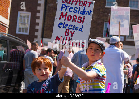 Londres, 07-07-2013. Deux jeunes enfants tiennent leur placard en altitude comme pro-Morsi égyptiens manifester devant l'ambassade du pays à Londres. Banque D'Images