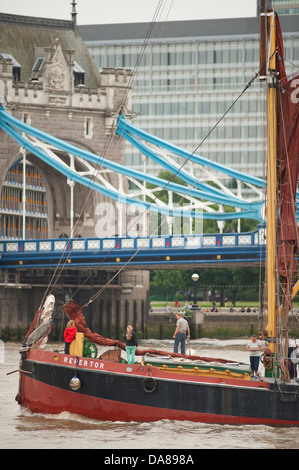 Thames Barge traditionnelle laissant St Katharine Docks dans le centre de Londres à marée haute avec le Tower Bridge en arrière-plan Banque D'Images