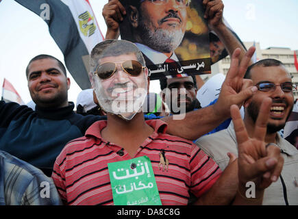 Le Caire, Le Caire, Égypte. 7 juillet, 2013. Les partisans du Président déchu Mohamed Morsi et les frères musulmans membres crier et politiques tiennent des pancartes dans son soutien en tant que ils manifester contre sa chute à Raba al-Adawyia mosquée le 7 juillet 2013, au Caire. La réalisation des photos du président déchu, les islamistes érigé des barricades et établi des postes de contrôle dans toute la capitale, où des dizaines de milliers d'entre eux ont bloqué la route principale de l'aéroport international Crédit : Ahmed Asad APA/Images/ZUMAPRESS.com/Alamy Live News Banque D'Images