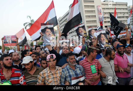 Le Caire, Le Caire, Égypte. 7 juillet, 2013. Les partisans du Président déchu Mohamed Morsi et les frères musulmans membres crier et politiques tiennent des pancartes dans son soutien en tant que ils manifester contre sa chute à Raba al-Adawyia mosquée le 7 juillet 2013, au Caire. La réalisation des photos du président déchu, les islamistes érigé des barricades et établi des postes de contrôle dans toute la capitale, où des dizaines de milliers d'entre eux ont bloqué la route principale de l'aéroport international Crédit : Ahmed Asad APA/Images/ZUMAPRESS.com/Alamy Live News Banque D'Images