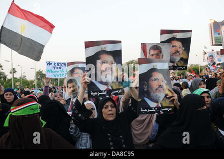 Le Caire, Le Caire, Égypte. 7 juillet, 2013. Les partisans du Président déchu Mohamed Morsi et les frères musulmans membres crier et politiques tiennent des pancartes dans son soutien en tant que ils manifester contre sa chute à Raba al-Adawyia mosquée le 7 juillet 2013, au Caire. La réalisation des photos du président déchu, les islamistes érigé des barricades et établi des postes de contrôle dans toute la capitale, où des dizaines de milliers d'entre eux ont bloqué la route principale de l'aéroport international Crédit : Ahmed Asad APA/Images/ZUMAPRESS.com/Alamy Live News Banque D'Images