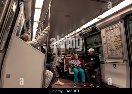 Les banlieusards, une jeune fille et un homme, s'asseoir en conversation sur un train de métro Métro de Washington D.C. Banque D'Images