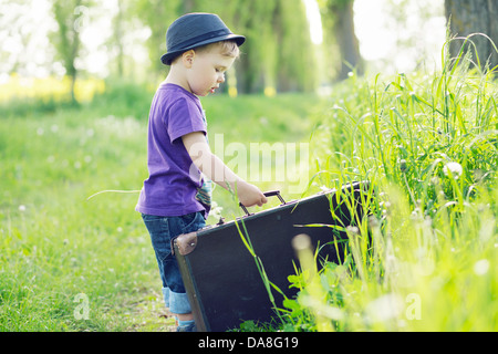 Photo de petit enfant qui tente d'échapper à suitcase Banque D'Images