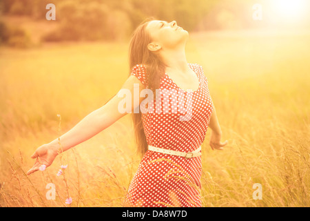 Relations sérieuses in de l'été. Jeune femme heureuse bénéficiant du soleil sur la prairie du blé Banque D'Images