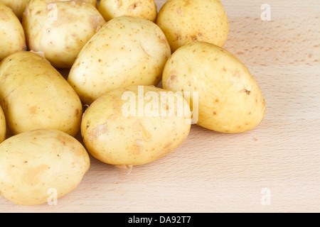 Nouveau Jersey Royal les pommes de terre sur une planche à découper en bois Banque D'Images