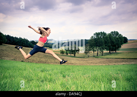 Jeune femme jogging en face de cross country Banque D'Images