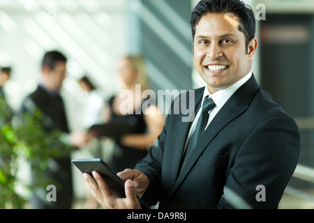 Cheerful young Indian businessman working on laptop in office Banque D'Images