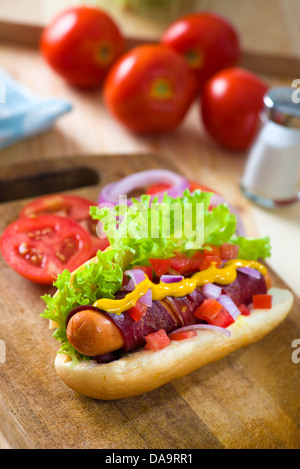 Hot-dog et bacon servi avec de la moutarde tomates et plein d'artifices Banque D'Images