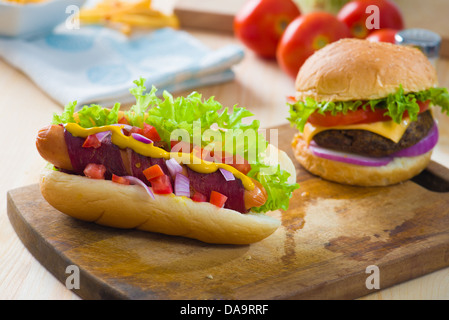 Hot-dog et bacon servi avec de la moutarde tomates et plein d'artifices Banque D'Images