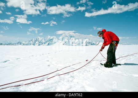 L'alpiniste se prépare à corde jusqu'au mont Logan en arrière-plan, dans les monts St-Elias, Territoire du Yukon, Canada. Banque D'Images