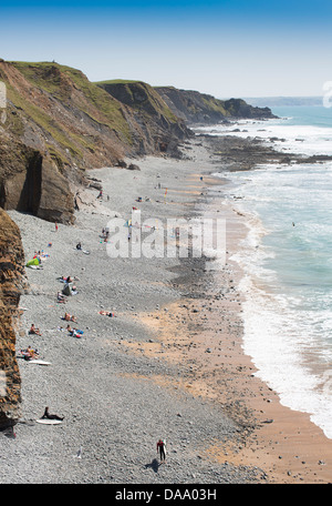 Les gens sur la plage de Sandymouth Bay, North Devon, Angleterre, vues du côté falaises surplombant la plage. Banque D'Images