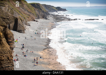 Les gens sur la plage de Sandymouth Bay, North Devon, Angleterre, vues du côté falaises surplombant la plage. Banque D'Images