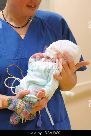 Une infirmière porte bébé Marie soigneusement dans ses bras à l'hôpital pour enfants de Hambourg, Allemagne, le 5 janvier 2011. Un portier a trouvé le bébé nouveau-né abandonné enfermé dans une valise devant le centre des congrès de Hambourg. Les infirmières de l'hôpital pour enfants de babtised 'Marie' le bébé. Le bébé est en bonne santé, la mère, cependant, est encore présente. Photo : Ralf Jakobs Banque D'Images