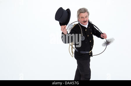 Ramoneur Guenther Gaux présente son uniforme de travail classique sur un toit à Duelmen, Allemagne, 14 décembre 2010. La routine de travail a beaucoup changé pour ramoneurs au cours de la dernière décennie. La disparition des fours à charbon a rendu inutile pour ramoneurs à escalader les toits. Dans l'année de 2010, un ramoneur a trouvé la plupart de ses travaux dans la chaufferie. L'une de ses tâches sans Banque D'Images