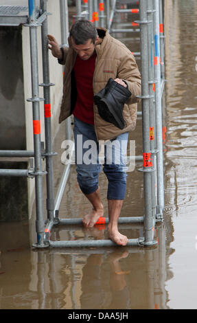 Un homme marche pieds nus à travers une rue inondée à Coblence, Allemagne, 09 janvier 2011. La fonte des neiges et les fortes pluies ont causé des niveaux d'eau dans les rivières du Rhin et de la Moselle. Photo : THOMAS FREY Banque D'Images