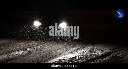 Chutes de neige en face de phares de voitures sur une rue dans le centre de Bad Wörishofen, Allemagne, 24 janvier 2011. Les régions du sud de la Bavière en ce moment y a beaucoup de neige qui mène à l'obstruction de la circulation. Photo : Karl-Josef Opim Banque D'Images