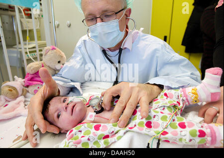 Dr. Hans Gerd Kehl, l'commissionary chef de la cardiologie de l'enfant, des tests sur le Ljuah Ahmeti exploités à l'aire de la cardiologie de l'Hôpital universitaire de Münster, Allemagne, 10 décembre 2010. La jeune fille est née avec une coarctation de l'aorte. Chaque année, 6000 enfants atteints de malformations cardiaques sont nés en Allemagne. Les chances de survie pour les jeunes patients a augmenté. Banque D'Images