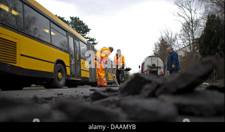 Personnel d'une compagnie roadmaking les révisions d'endommager la surface de la route à Dresde, Allemagne, 08 février 2011. Gel, dégel et les conditions hivernales ont causé des dommages à la surface des routes sur toute l'Allemagne. Photo : Arno Burgi Banque D'Images