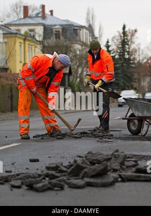 Personnel d'une compagnie roadmaking les révisions d'endommager la surface de la route à Dresde, Allemagne, 08 février 2011. Gel, dégel et les conditions hivernales ont causé des dommages à la surface des routes sur toute l'Allemagne. Photo : Arno Burgi Banque D'Images