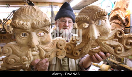 Hermann Obenauer dans der Werkstatt senneur à Oberstdorf (Schwaben) zwei von ihm gefertigte Brauchtumsmaske Zirbenholz Tiroler aus (Foto vom 11.01.2011). Mehr als 2000 Masken hat der Tischler und in den vergangenen Maskenschnitzer geschnitzt zu vier Jahrzehnten (dpa-KORR vom 06.02.2011 :'Freude am Holz : seit 40 Jahren Allgäuer schnitzt Faschingsmasken). Foto : Karl-Josef Opim Banque D'Images