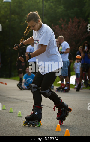 Teenage girl roller à travers les cônes de slalom Banque D'Images