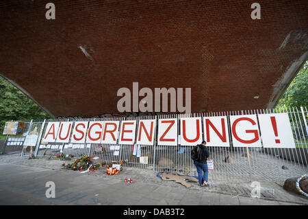 Un piéton se lit une protestation des affiches sur une clôture sous un pont à Hambourg, Allemagne, 26 septembre 2011. Sous le pont sans-abri a dormi pendant des années jusqu'à ce que le bureau de district construit la clôture pour 18 000 euros. La clôture doit éviter la zone du sans-abri. Photo : CHRISTIAN CARISIUS Banque D'Images