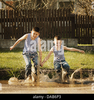 Deux garçons in puddle Banque D'Images